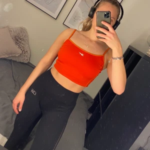 Röd/orange träningstopp linne - Snyggt träningslinne i nyckick! Kommer tyvärr inte ihåg vad märket heter. Svettvänligt material och superstretchigt. Kolla gärna in mina andra plagg så kan du få samfrakt och vi kan komma överens om ett paketpris🥰