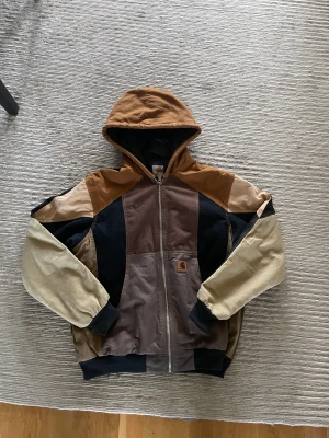 Vintage 1 of 1 custom carharrt jacka - En unik carharrt jacka i storlek M, jackan är i bra skick med coola detaljer och en lite boxig passform. Den är i grunden en vintage carharrt duck active jacka men nya delar från andra carharrt plagg har blivit sydda på den. Kan fixa frakt