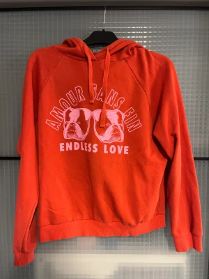 Hoodie  - En röd hoodie från Gina ett tryck som är rosa! Så fi men tröttnat den är varm och go! Skön i matriset! Skulle säga att den är mer som en M i storleken
