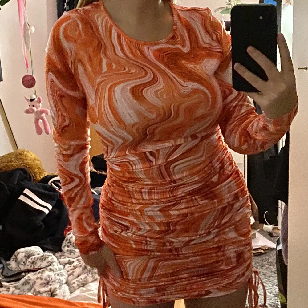 Orange melerad klänning från Shein. Den har dragsnörning på båda sidorna så man kan ha klänningen både lång och kort, det gör man som man vill. Sista bilden är från modellen. Långärmad. Väldigt skönt material!. Klänningar.