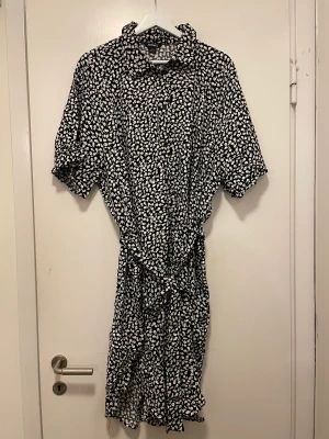 Svart klänning från Monki - Aldrig använd.  Svart, blommig klänning från Monki. Avslappnad passform.  Säljer pga felköp.