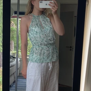 Söt sommartopp strl S - Jättegulligt sommarlinne från HM. Använt en gång, mycket bra skick. Fina snörningar vid axlar och i midjan som går att anpassa beroende på hur det ska sitta. Söt grön färg som passar till allt!