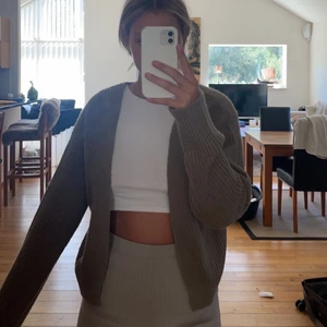 Stickad kofta - Stickad kofta från JJXX köpt på Nelly. Säljes då den inte kommer till användning alls. Använd enbart på bilder och därför i nyskick. Storlek L då jag vill ha den lite större och inte tight, är ca 175 cm lång