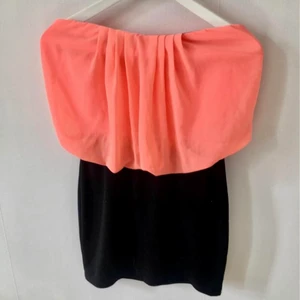 Tub klänning volang VILA S/M Korall - Snygg klänning från vila. Tubtopp med takt svart stretchig nederdel. Färg: korall överdel och svart kjol. Stlk M men passar S även. Stretchig.