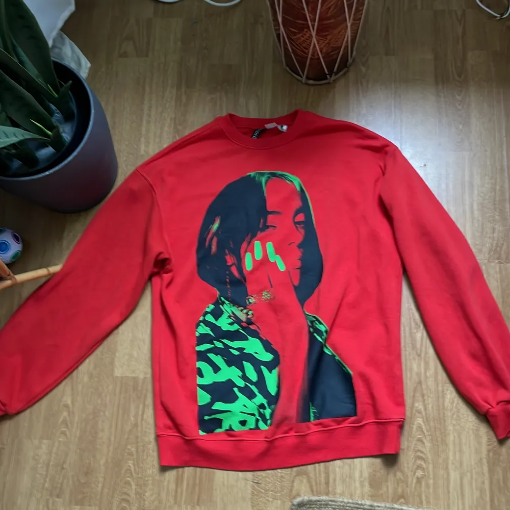 Nästan aldrig använt,  Billie eilish tröja röd med grön text på ryggen och en svart och grön bild på själva billie på framsidan .(köparen står för frakten ) om ni har mer frågor skriv så sk jag försöka svara . Tröjor & Koftor.
