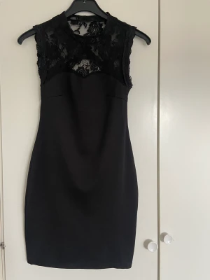 Kort svart klänning, spets, öppen rygg - Lårkort klänning från Rut&Cirkle med spetsdetaljer och öppning i ryggen. Använd en gång, nyskick 