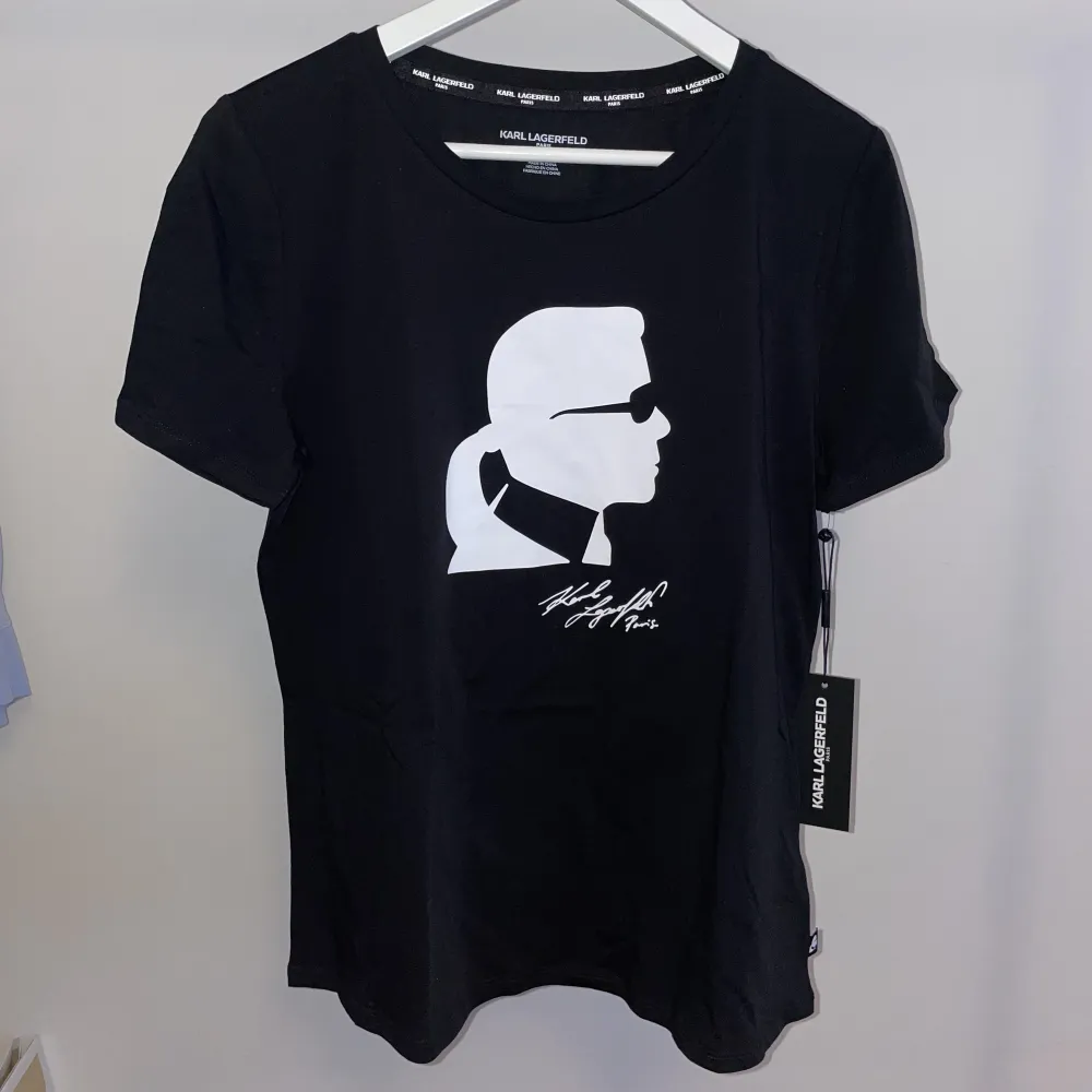 T-shirt med tryck från Karl Lagerfeld. Helt ny, oanvänd med lappar kvar. Funkar när man ska var uppklädd men också till vardags. . T-shirts.