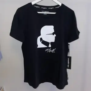T-shirt med tryck från Karl Lagerfeld. Helt ny, oanvänd med lappar kvar. Funkar när man ska var uppklädd men också till vardags. 