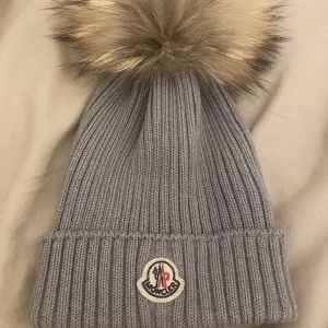 Moncler mössa - Moncler mössa i barnstrl L,köpt i andrahand av mig men kommer inte till användning.Superfint skick och syns knappt att den är använd!Den jag köpte mössan av hade skrivit sitt namn inuti men inget man tänker på, självklart äkta dock är koden nött!
