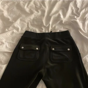 Juicy velour pants ( LÅNAD BILD!!!!!))))) - Intressekoll på mina svarta juicy byxor (velour) , har haft de några månader! De är i bra skick skulle jag säga förutom att ena metall saken på snöret har lossnat + de finns ett litet brännmärke på låret men inget man märker av❤️ LÅNAD BILD!!!! 