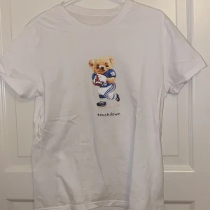 Vit T-shirt med björntryck S-M - En Vit T-shirt med tryck. Skulle säga att storleken ligger mellan S-M. Kanske lite stor för att vara S men passar absolut någon med den storleken.