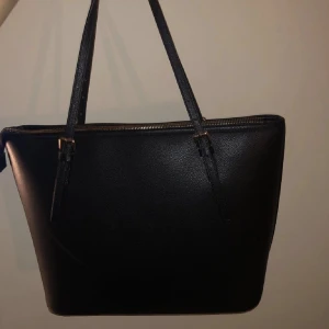 Handväska - En svart, guldig handväska med två innefickor🤩Nästan helt oanvänd och säljer pågrund av att jag har en annan väska! 😊Bredden är 35 cm och längden är 25 cm😀skriv till mig för fler frågor!