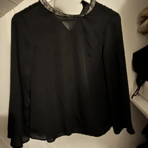 Blus  - Svart blus med en krage som bär på svart silvriga vita stenar från Zara i strl XS. Några år, men använd ett fåtal gånger max 5 så den har mycket kvar att ge i någon annans garderob. Inget att anmärka på.   