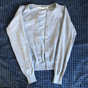 Grå kofta  - En grå basic kofta från lager 157 men knappar hela vägen ner