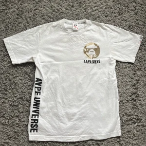 Aape T-Shirt - Aape by Bape T-shirt i storlek M, bra skick förutom två mindre fläckar på framsidan. Skriv för fler bilder osv.