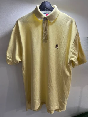 Tommy Hilfiger Piké gul retro 80-tal - Märke: Tommy Hilfiger Typ: Piké Storlek: M Färg: Gul Material: Bomull Mönster: Enfärgat Kroppstyp: Man Passform: Regular