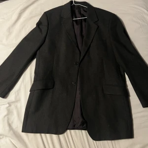 Overzied mörkgrå kavaj - sjuktfin mörkgrå kavaj🤩Den är overzided i modellen skulle säga att den kanske är en L i damstorlek. Perfekt till sommaren med t.ex en klänning och några stövlar😍 Den har även både inner och ytterfickor🤩 Skriv gärna för fler bilder eller frågor! 
