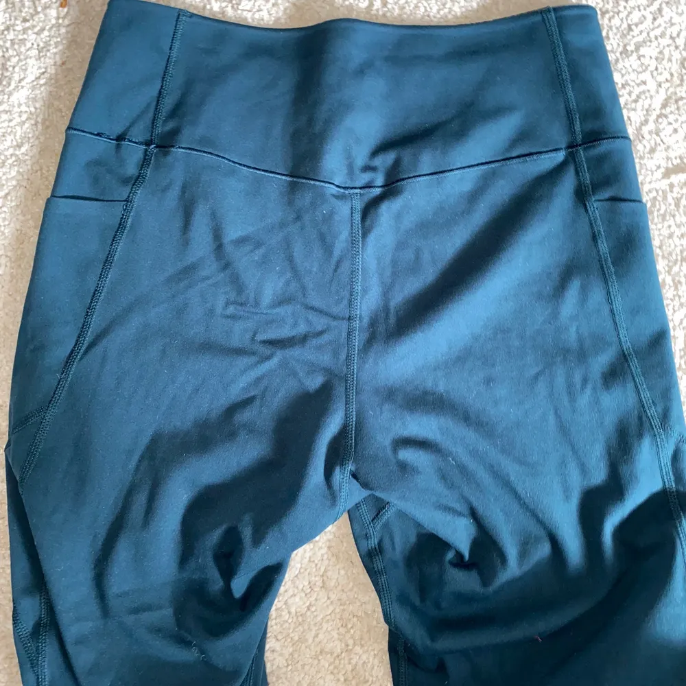 Ett par blågröna träningstights från uniqlo med fickor längs sidorna. Tightsen är ifrån OS-kollektionen så vet inte om de har sålts i butik. Väldigt skönt material och aldrig använda så är i nyskick!💚. Jeans & Byxor.