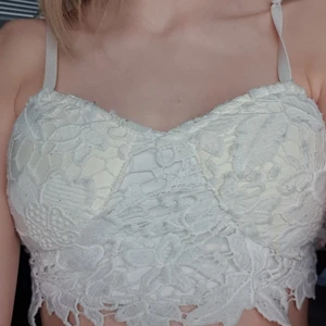 Top strl M - Den är vit och är ganska kort. Den är stretchig och har ett mönster av blommor på framsidan. Jag tar 80kr för denna. 