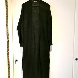 Lång kofta från Monki - En svart, lång stickad kofta från Monki i storlek XS. Längd 130 cm 