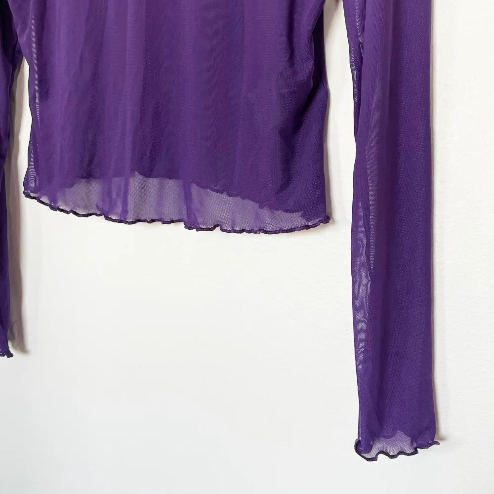 Mesh genomskinlig lila tröja från H&M, den har fina virvlar på kanterna på tröjan, ärmen och halsen.   Endast använd en gång därmed nyskick.. Toppar.