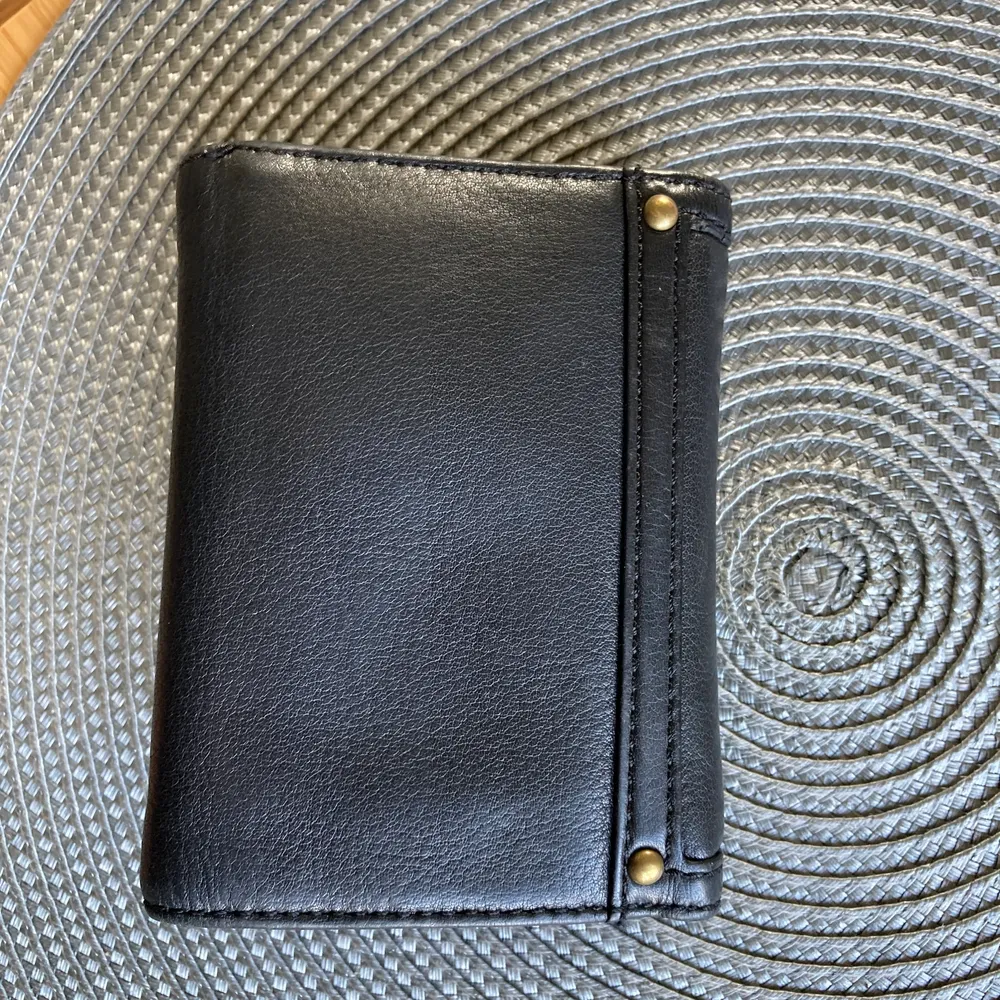 Mellanstor svart läder plånbok med flera fack för både kort, sedlar samt mynt. Använd dryga året bara och då väldigt sporadiskt så är i fint skick både inuti och runt om! . Väskor.