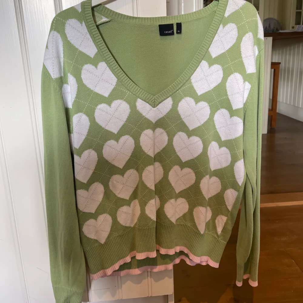Snygg tröja i Y2k stil, grön med vita hjärtan och en rosa rand längst ner. Står Strl XL men jag som är en liten S har haft på mig den, sitter som en M. . Tröjor & Koftor.
