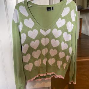 Snygg tröja i Y2k stil, grön med vita hjärtan och en rosa rand längst ner. Står Strl XL men jag som är en liten S har haft på mig den, sitter som en M. 