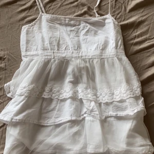 vit volangtopp med band  -  Säljer min vita volangtopp då den tyvärr inte passar mig längre. Påminner mig om de söta brandy topparna! Sitter som en xs/s. Går att justera banden:)