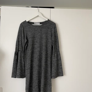 Gråmelerad klänning - En höstklänning med vida armar och snörning. Gråmelerad. 