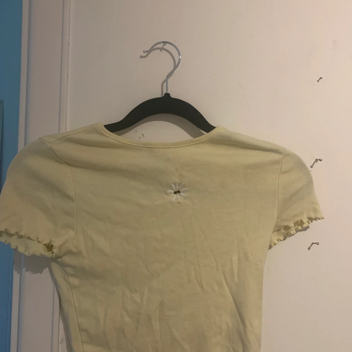 Jag säljer en gul topp med en fin sol på framsidan.