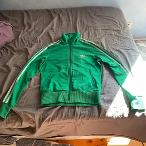 Grön Adidas hoodie - Tröjan är i storlek 38 och ganska bra skick förutom en liten fläck på ärmen.
