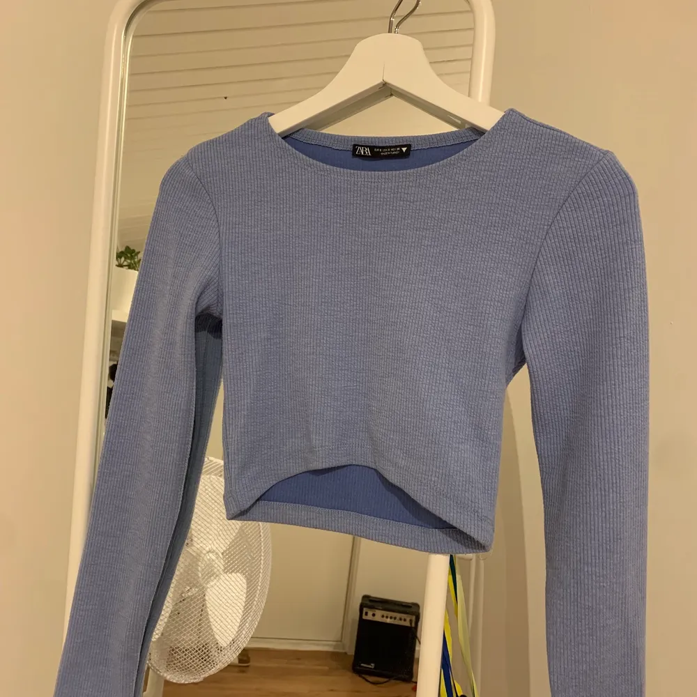 En väldigt fin blå långärmad crop top köpt från zara, ribbad. Toppar.