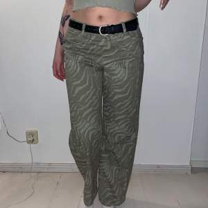 Wide, low waist gröna/oliv färgade jeans med svagt mönster i storlek 38. Frakt ingår ej i priset