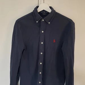 Ralph Lauren Skjorta - Mörkblå skjorta från Ralph Lauren i strl S (slim fit).  Nypris ca 1 199kr.  Finns på Östermalm i Stockholm. Kan postas mot förskottsbetalning. 
