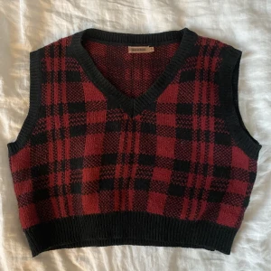 Rutig väst - Rödrutig stickad väst, super söt! Obs, spegeln är smutsig och inte plagget.