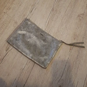 Snygg silvrig kuvertväska. Clutch. Parfois. - Snygg kuvertväska. Silver. Fint skick.
