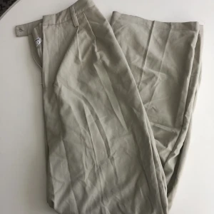 Beiga kostymbyxor - Snygga kostymbyxor som är insydda för att passa en S. Går snyggt över skorna. 
