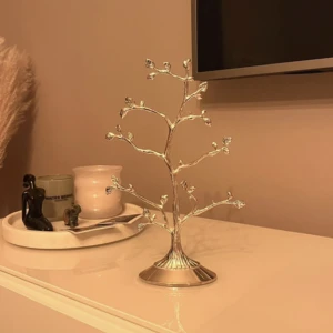 Smyckesträd - Ett Smyckesträd från guldfynd. Den är gjort av putsfritt nysilver. Inga som helst repor vid användning, ser ut som ny! Nypris var 379 kr, jag har knappt använt den och säljer därför för 200 kr. Pris kan diskuteras! 