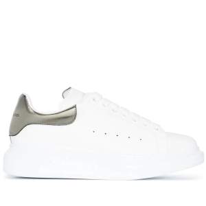 Vita Alexander McQueen sneakers med metallic. Väl använda men har definitivt mer att ge! Slutage finns på insidan av hälen i ena skon, samt repor bak på märket. Mycket går bort när man putsar dem! 