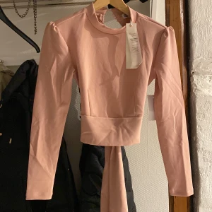 Topp - Oanvänd ljusrosa topp med öppen rygg. Från Alexandra Nilssons kollektion.