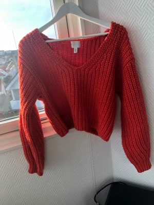 Stickad tröja - Ny, oanvänd stickad tröja i skönt material från H&M. Röd/orange, starkare färg än visat på bild.