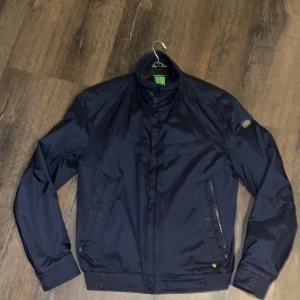 Hugoboss bomberjacka  - Säljer min vår/höstjacka, knappt använd varm och skön 2innefickor samt dubbla fickor på utsidan . hugoboss patch på sidan samt framsidan, knappt använd nypris 4800