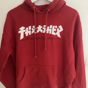 Röd thrasher hoodie - Snygg röd thrasher hoodie i storlek M men som sitter lite oversized. Köpt för 799kr och är i mycket bra skick!