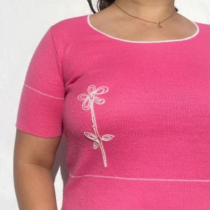Vintage stickad rosa topp - Vintage stickad rosa topp med korta ärmar och blommotiv. Köpare står för frakt.