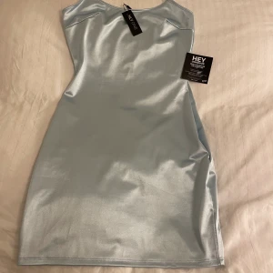 Satinklänning - Ljusblå satinklänning från Nelly I storlek S. Helt oanvänd med alla prislappar kvar. Nypris: 299kr