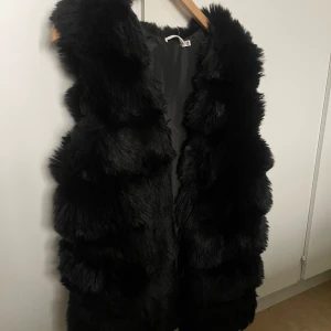Svart pälsvest (fusk)  - Svart pälsvest i fuskpäls.