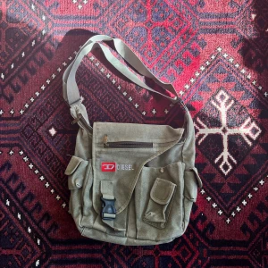 Diesel crossbody bag - En skitcool väska från diesel! Den är ganska stor, får plats med tex en laptop så en perfekt skol väska! 