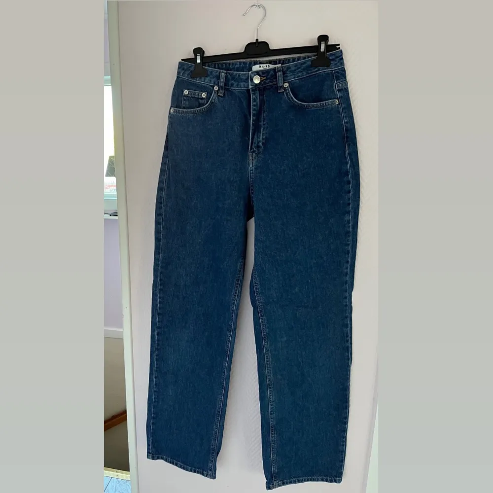 Mörkblå högmidjade vida jeans från NA-KD i storlek 38, använda ca 5 ggr. Säljer då jag ändrat stil. Inga avvikelser på de. Köpta för 499kr, säljer för 300kr då de knappt är använda. Är perfekta på mig som är 170cm och brukar ha 38/M.. Jeans & Byxor.