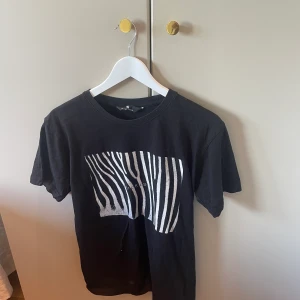 The cool elephant T-shirt  - En svart vit T-shirt från the cool elephant. Köpt för kanske 2 årsen och använd kanske 5 gånger? Den finns inte kvar på hemsidan❤️